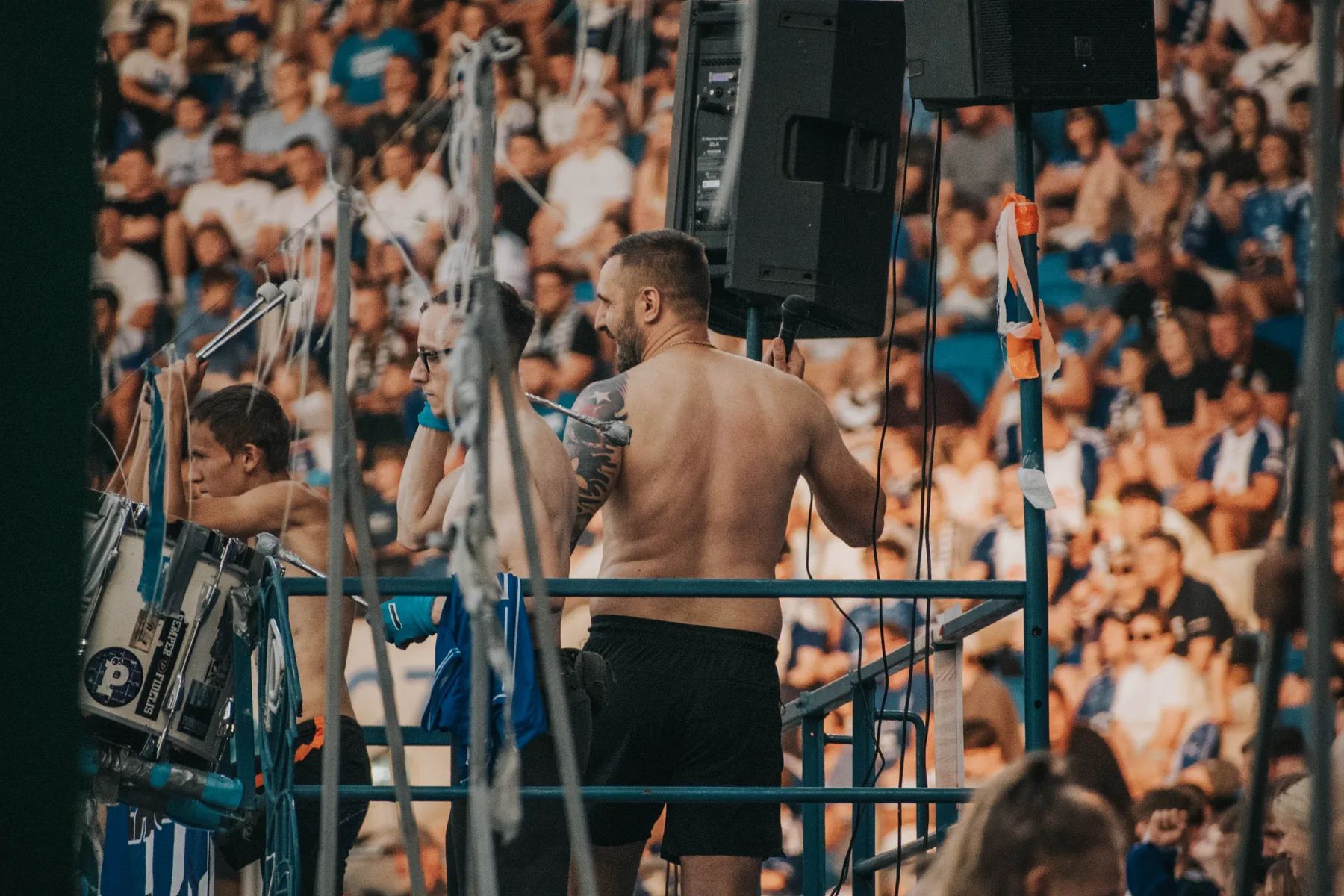 Zawodnik na ringu i ekipa techniczna podczas wydarzenia sportowego.